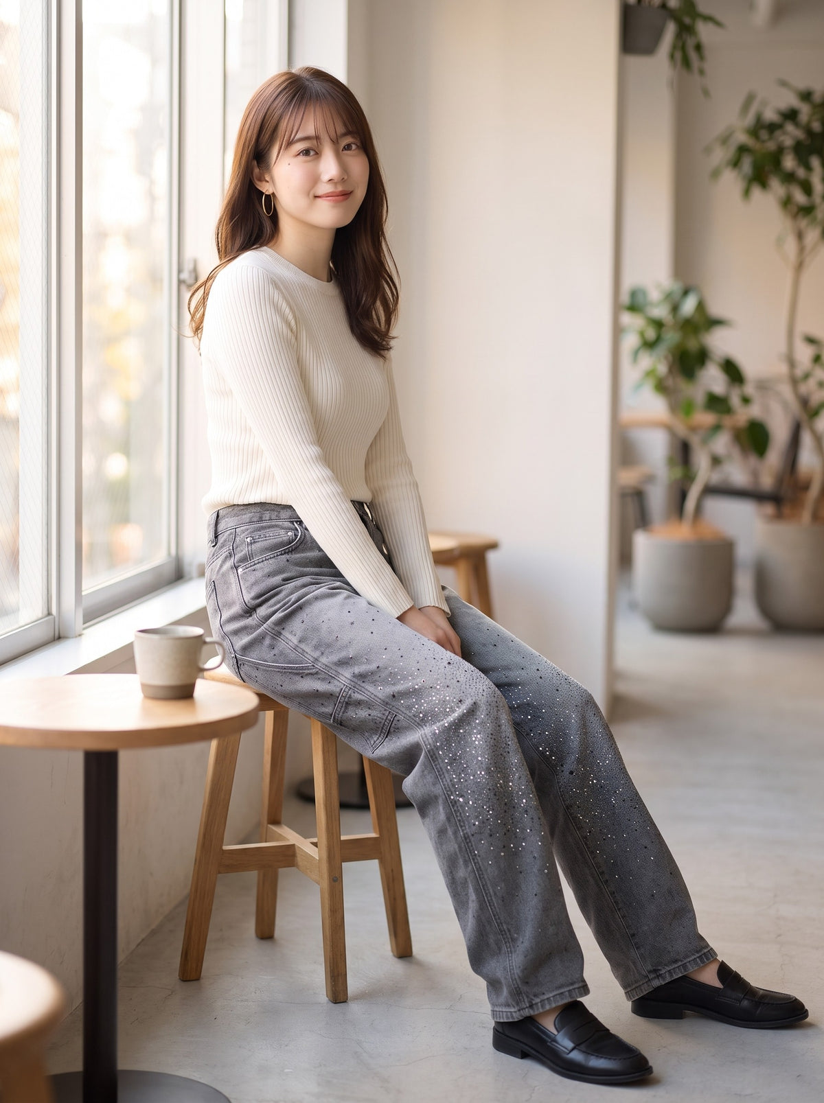 グレイのバルーンデニムを着てカフェで座るコーディネート