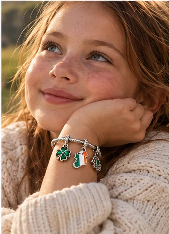 A young girl with freckles looking up, wearing the charm bracelet