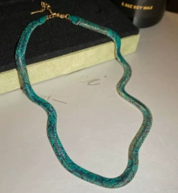 Supplier photograph of the green flat python mesh necklace, showing the clasp and extender.