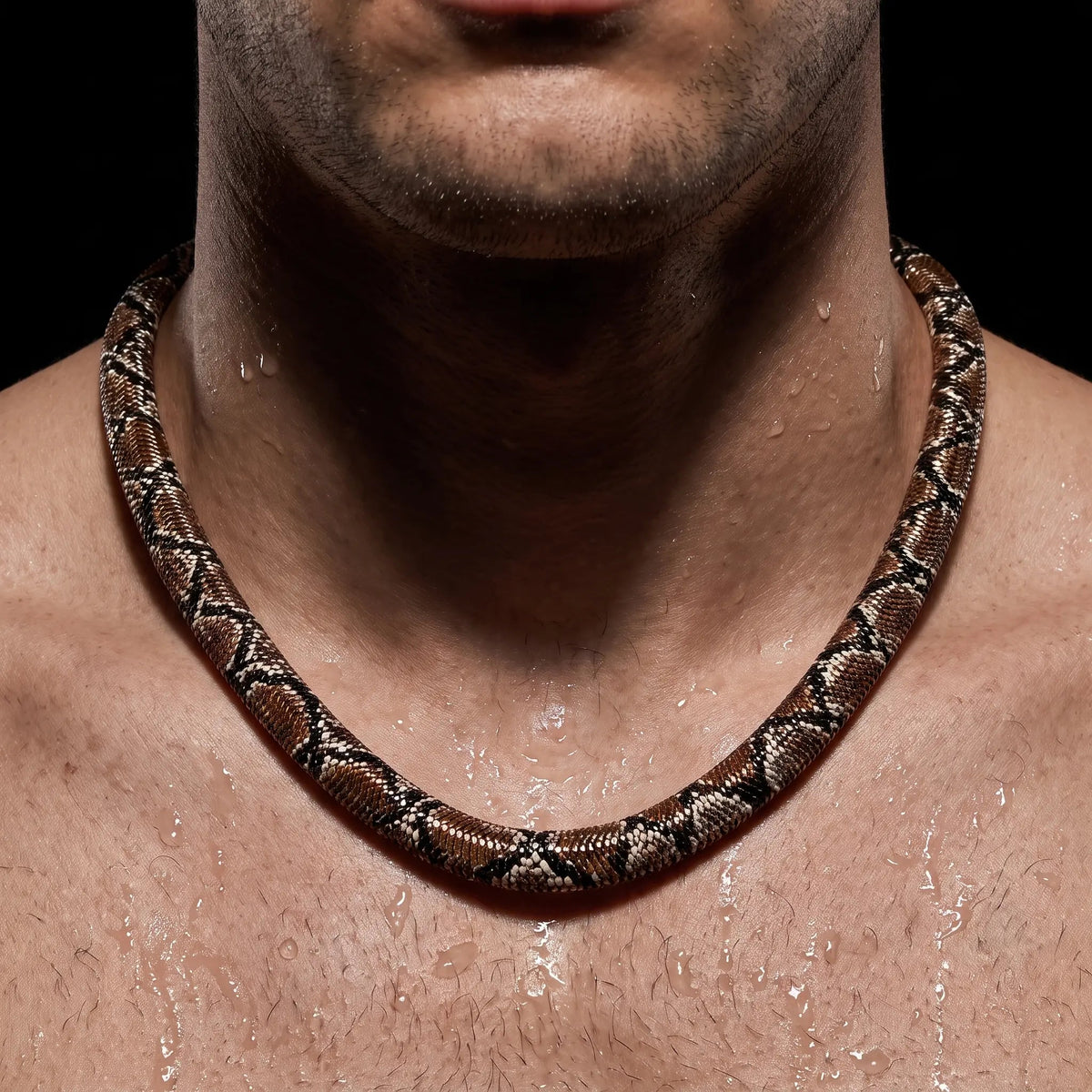 Close-up of the python-pattern necklace on a man's bare neckline