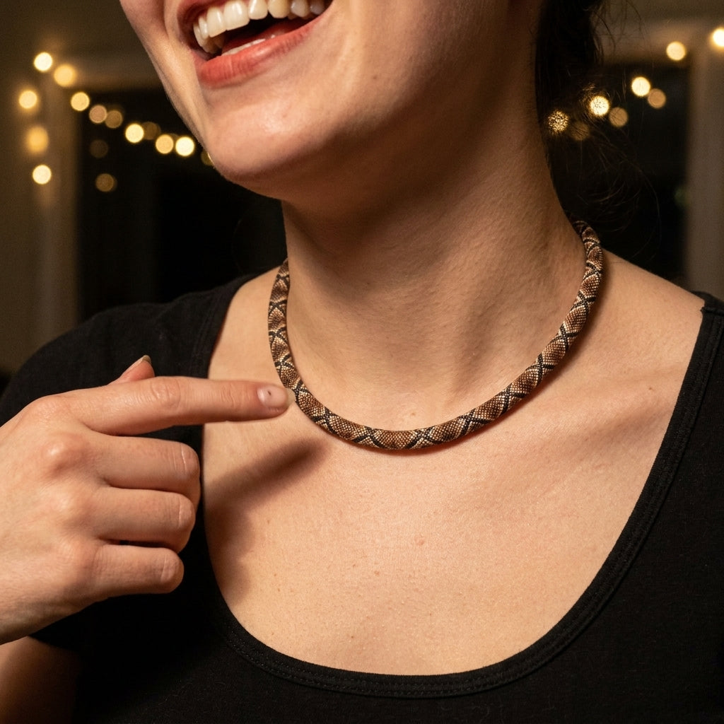 Close-up of the python-pattern necklace on a woman's neckline, over a black top