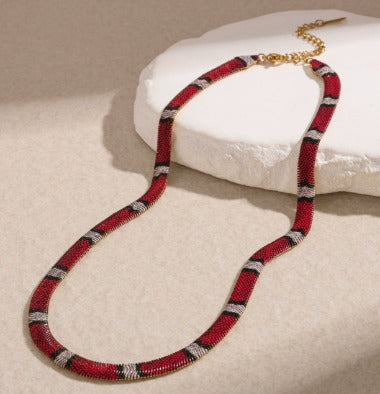Supplier photograph of the red-ivory flat python mesh necklace, showing the clasp and extender.