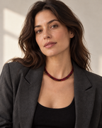The red flat python mesh necklace styled on a woman in natural daylight.